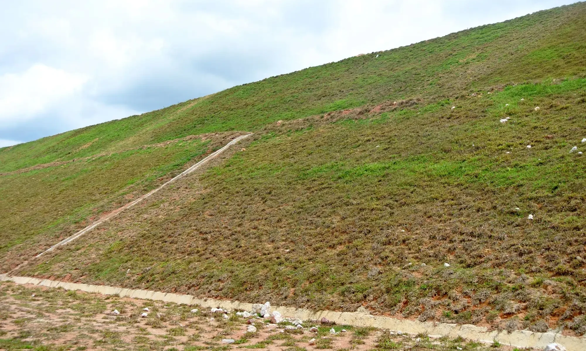 Hydroseeding being applied across a large rural acreage property in Alberta with open terrain and wide coverage